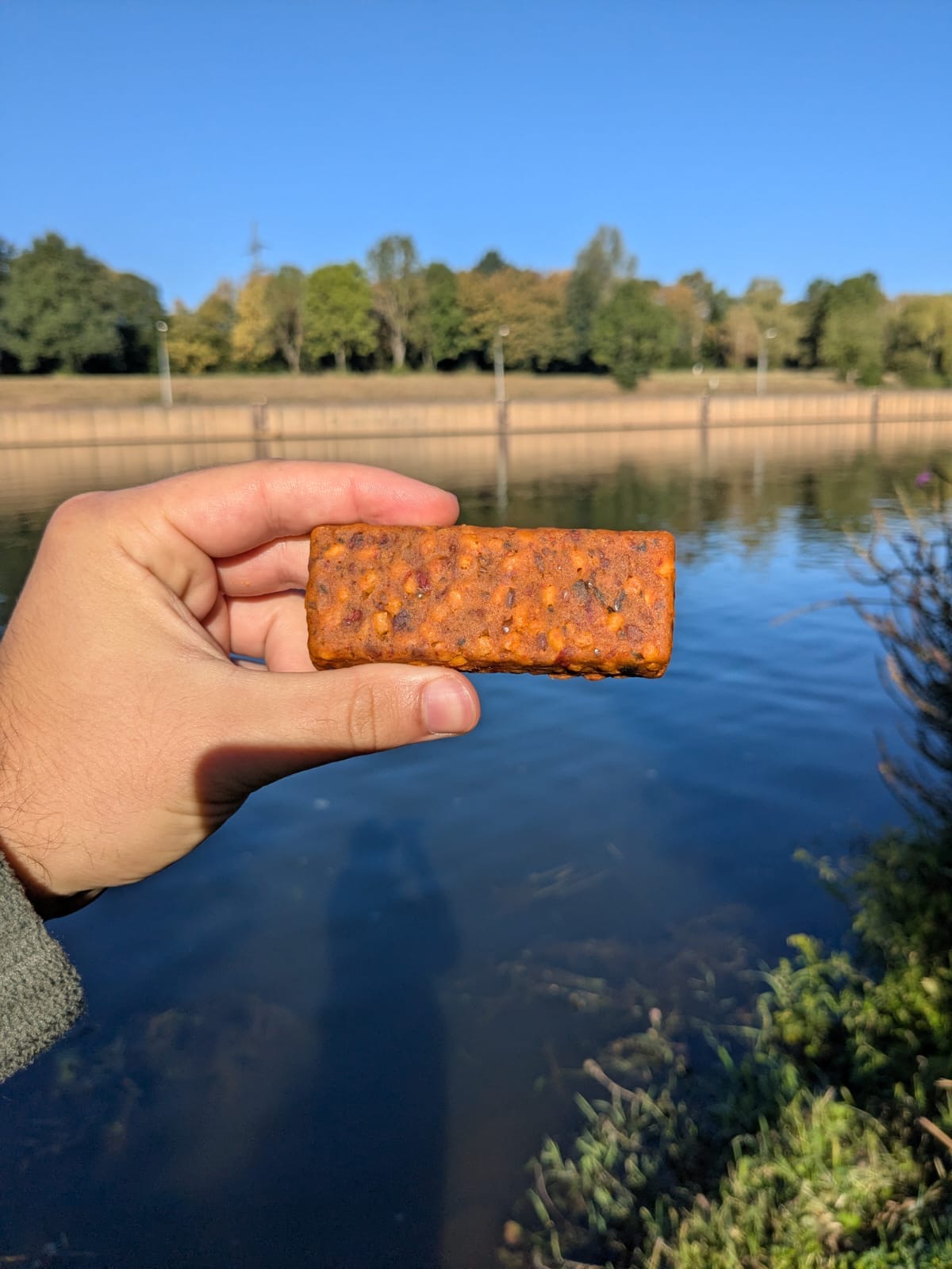Originaler Fuelbite-Riegel ohne Verpackung, in einer Hand am See